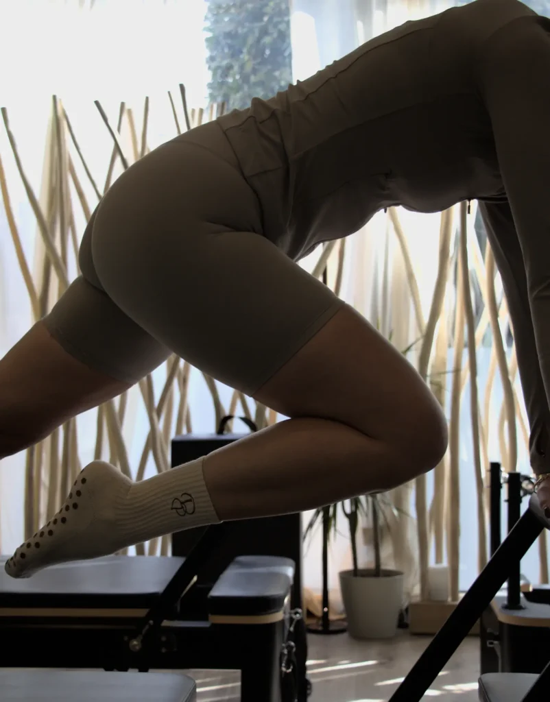 Élève intermédiaire en séance de Pilates Reformer cours Essentiel à Enghien-les-Bains